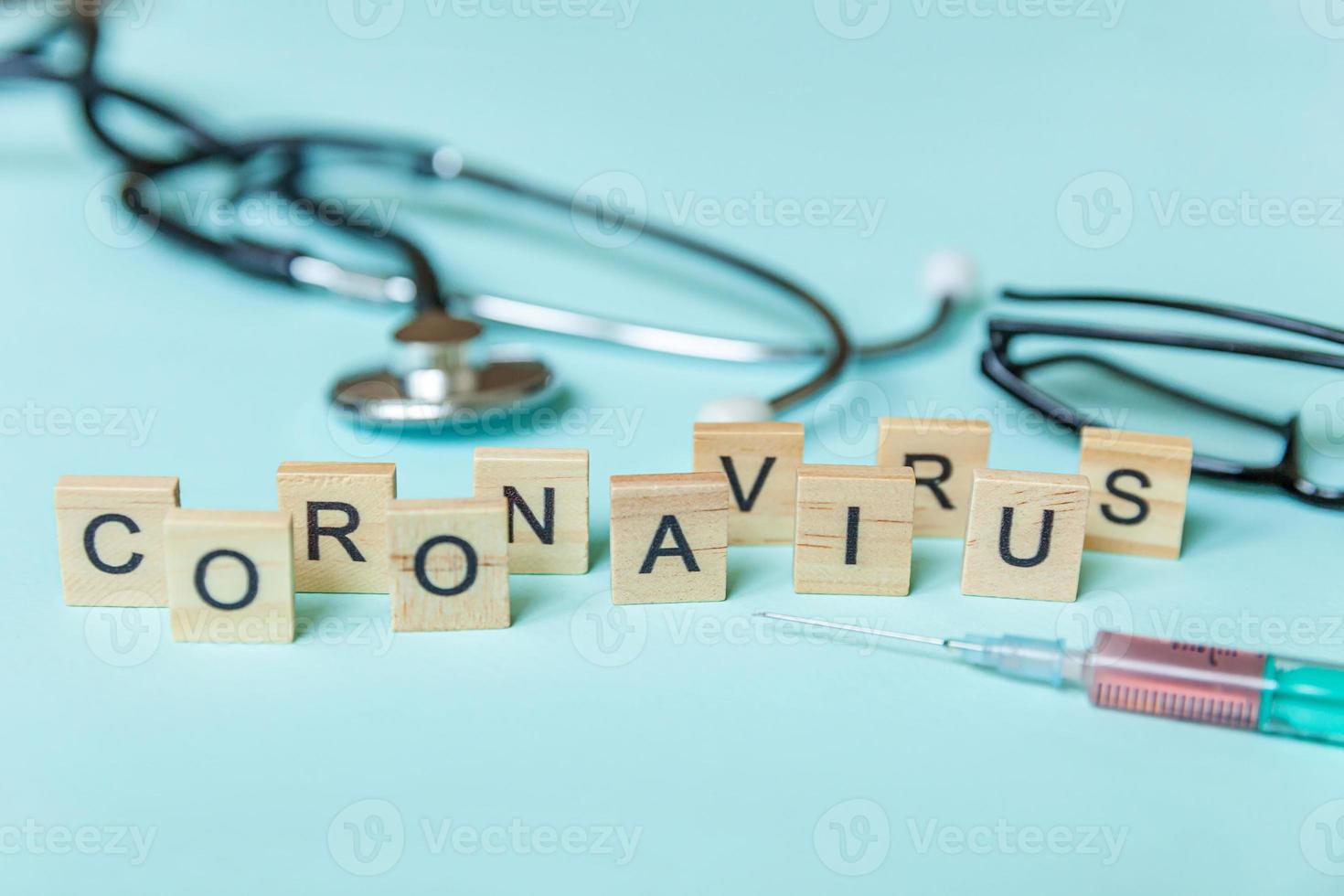 textfras coronavirus spruta glasögon och stetoskop på blå pastell bakgrund. nya coronavirus 2019-ncov mers-cov covid-19 Mellanöstern respiratoriskt syndrom coronavirus virus vaccin koncept. foto