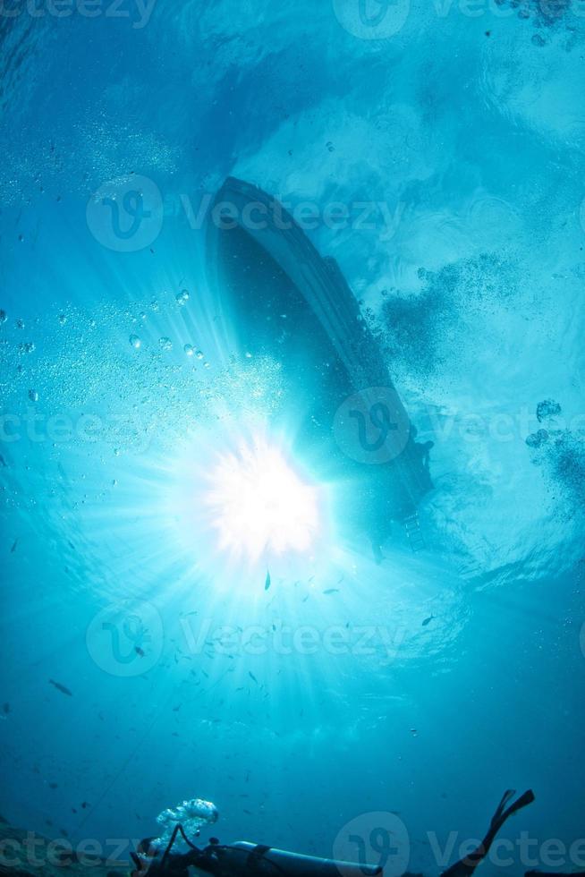 dykning båt fartyg från under vattnet blå hav med Sol strålar foto