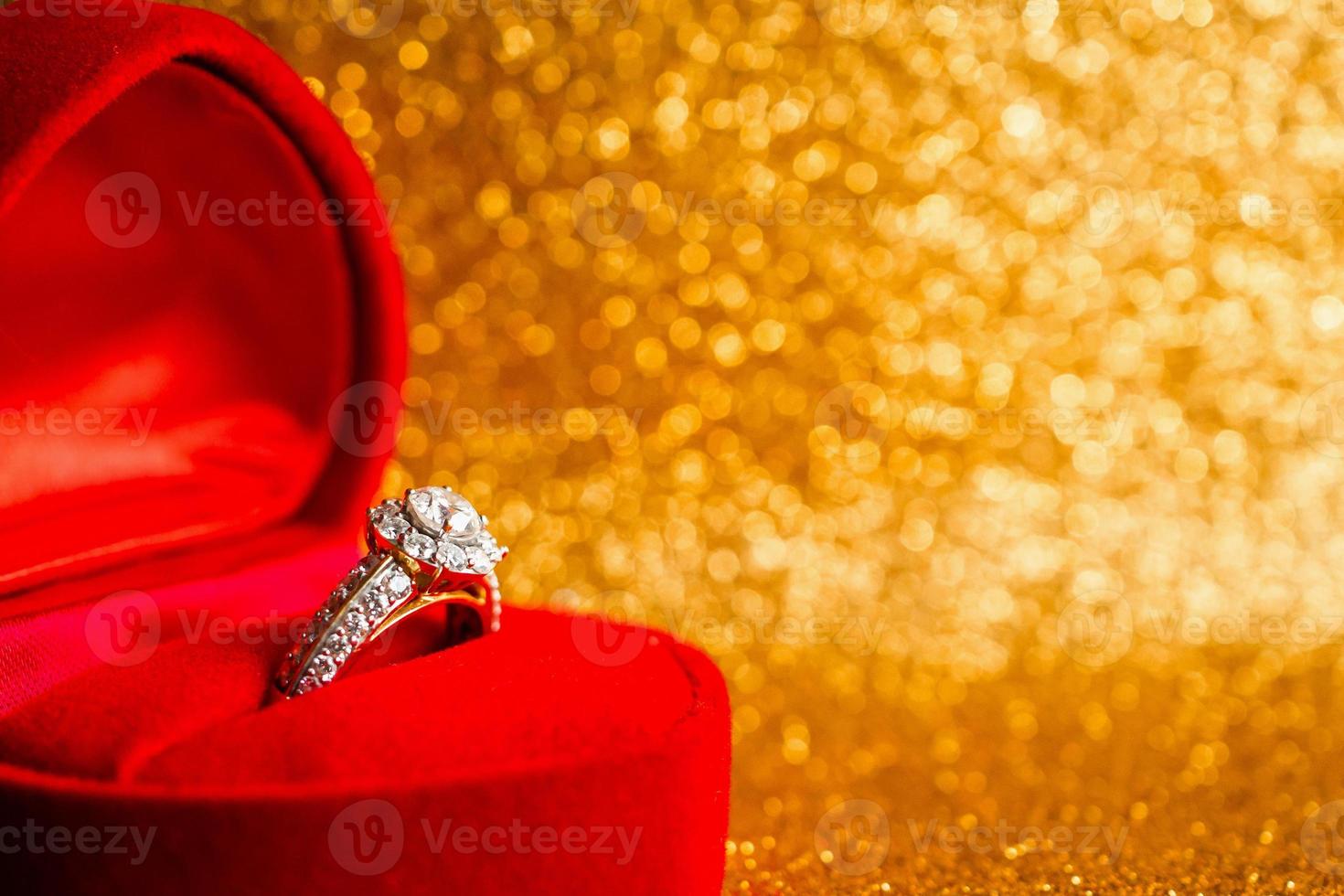 smycken diamantring i presentförpackning med abstrakt festlig glitter julhelg textur bakgrundsoskärpa med bokeh ljus foto