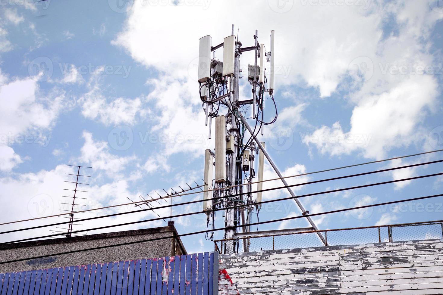 kommunikation torn med antenner på de topp av byggnad och ljus blå himmel med stor moln bakgrund. foto