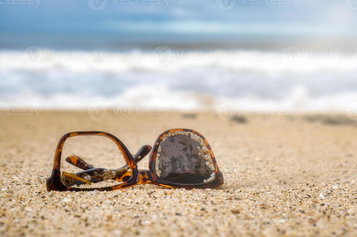 solglasögon skräp kastas i de hav på de sand foto