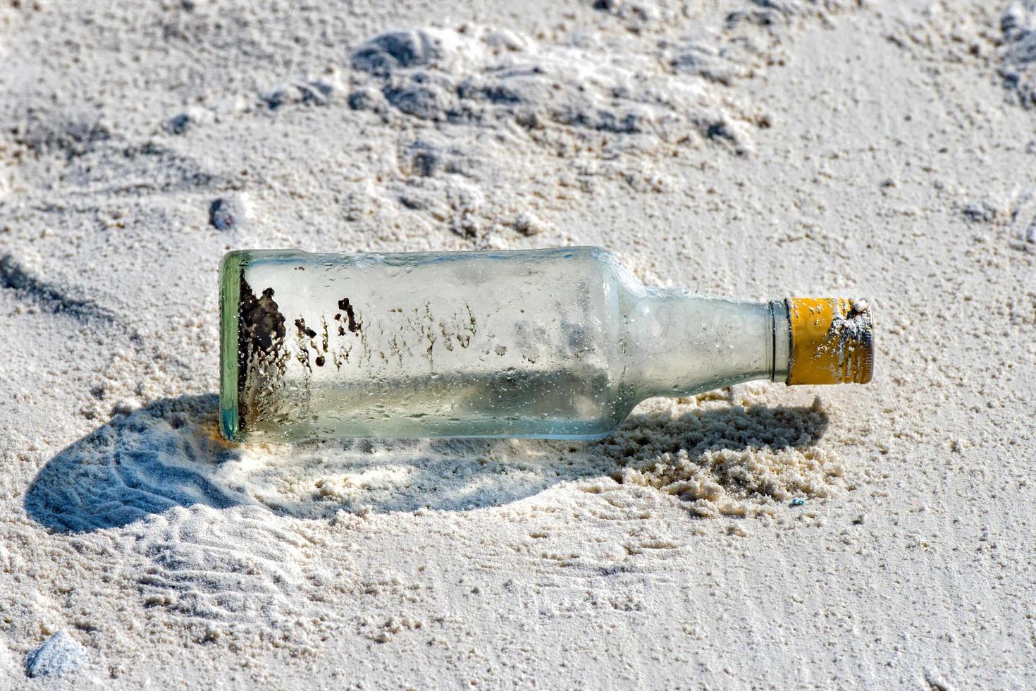 meddelande i en flaska övergiven på sandig strand foto