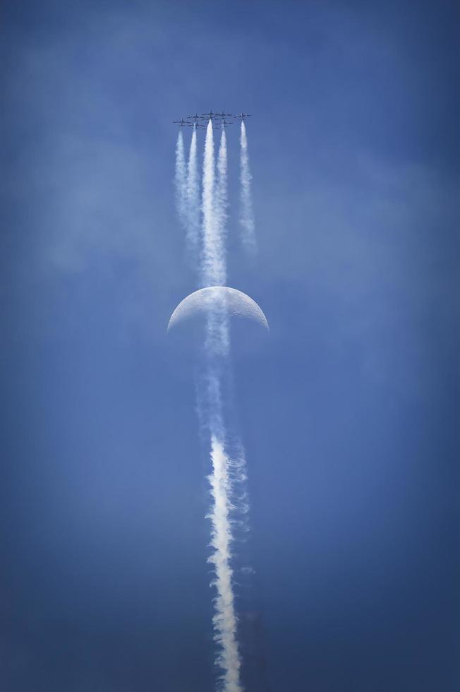 flygplan som flyger i formation med månen i bakgrunden foto