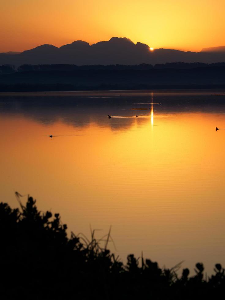 sjö under gyllene solnedgången foto