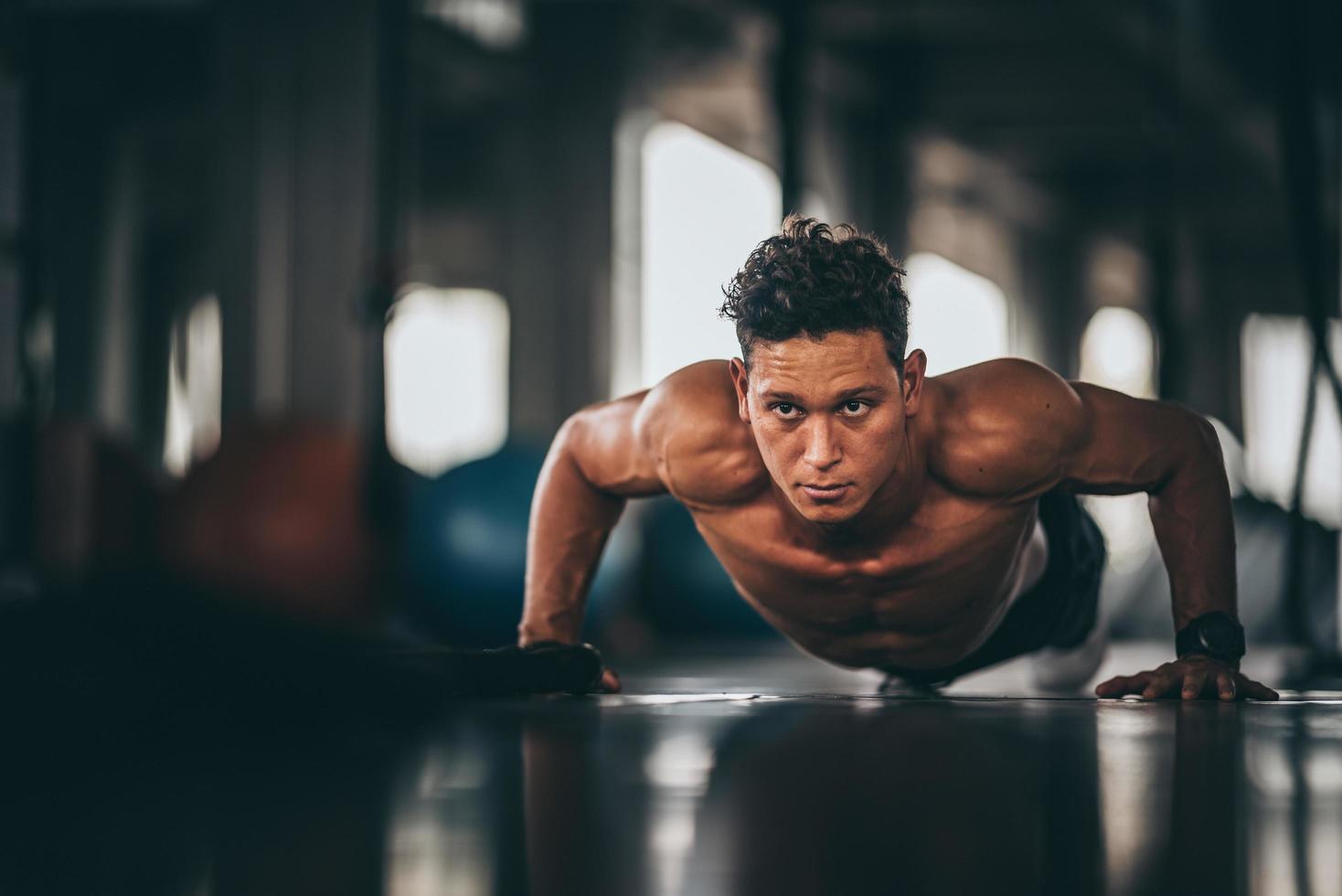 manlig idrottsman som gör armhävningar på gymmet foto