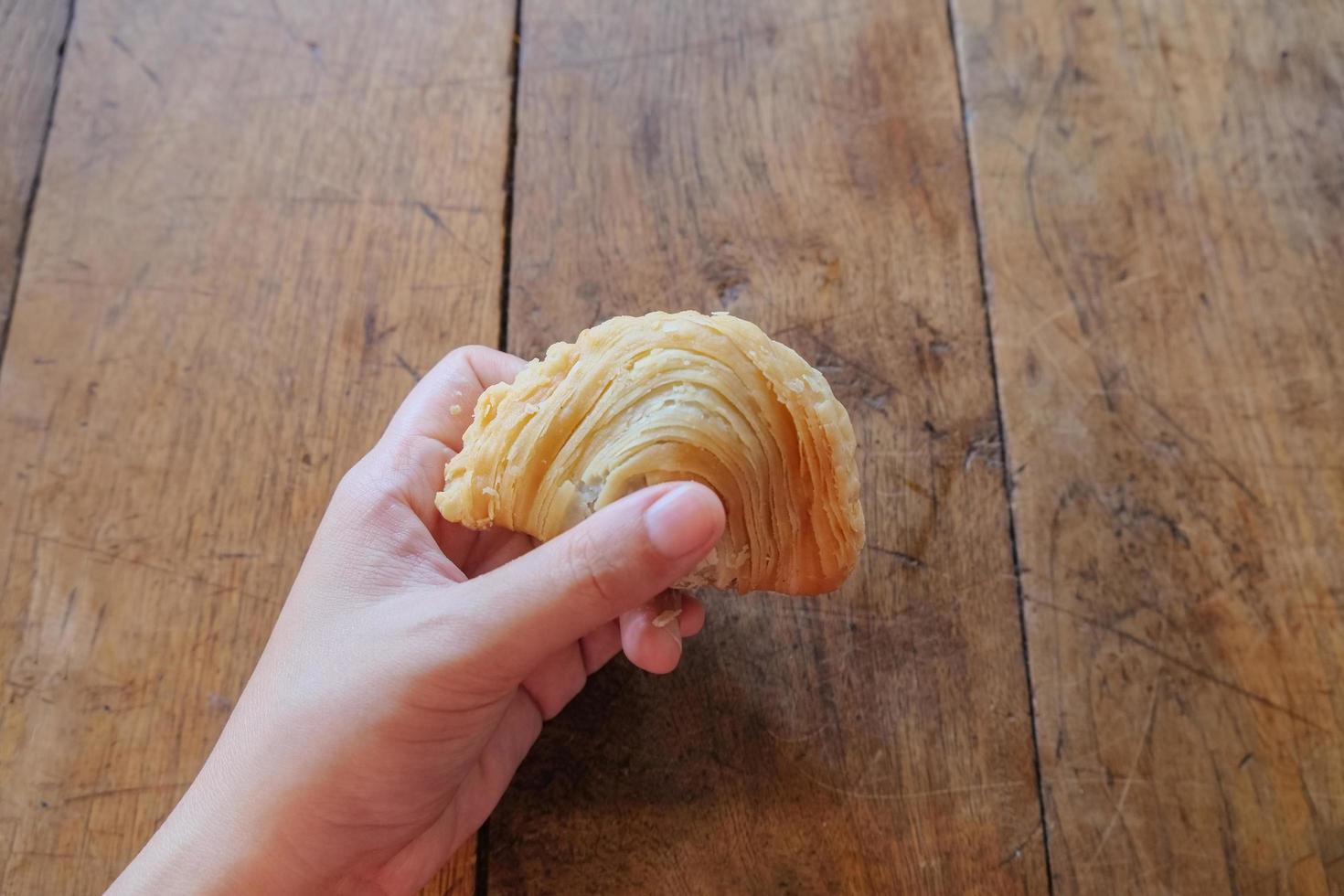 en resenär som håller en bit av lokal thailändsk stil mellanmål krispig kyckling curry puff på lokal gatamat färsk marknad. Bangkok, Thailand. foto