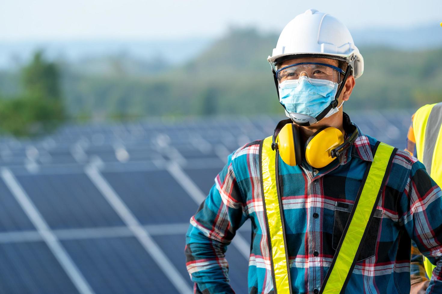 man bär säkerhetsutrustning bredvid solpanelen foto