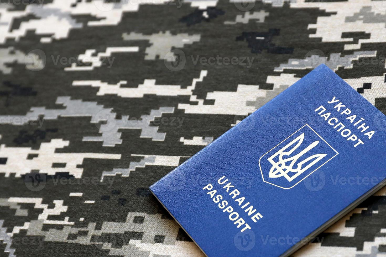 ukrainska utländsk pass på tyg med textur av militär pixeled kamouflage. trasa med camo mönster i grå, brun och grön pixel former och ukrainska id foto