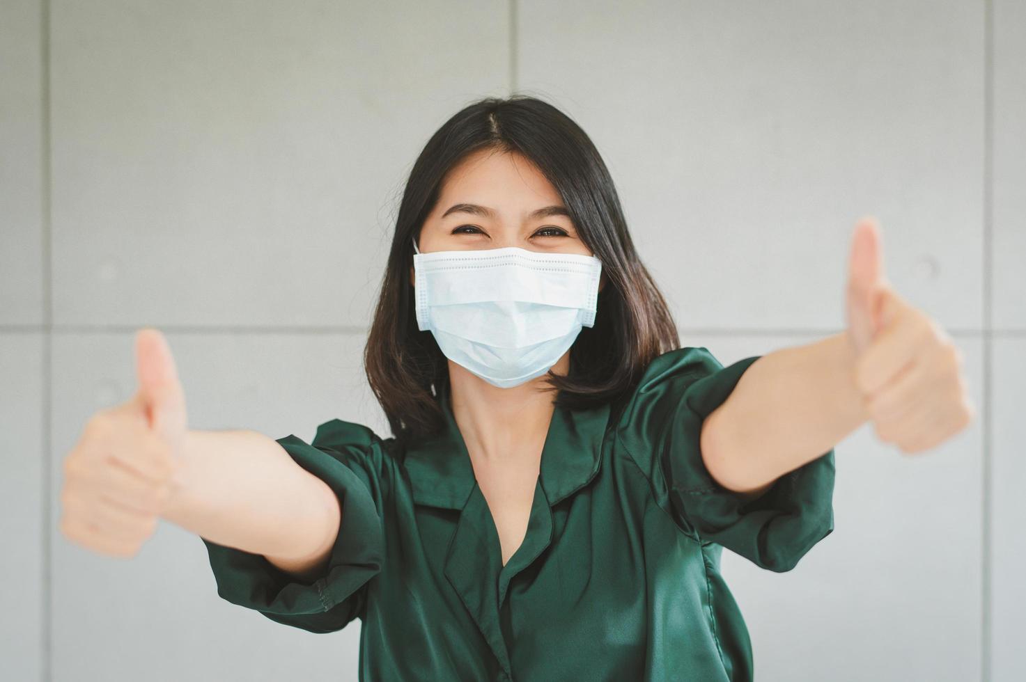glad kvinna som bär medicinsk ansiktsmask foto
