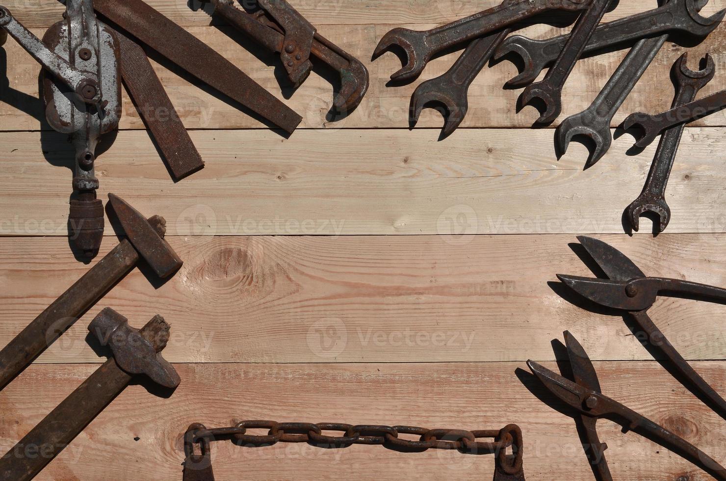 en uppsättning av gammal och rostig verktyg lögner på en trä- tabell i de verkstad foto