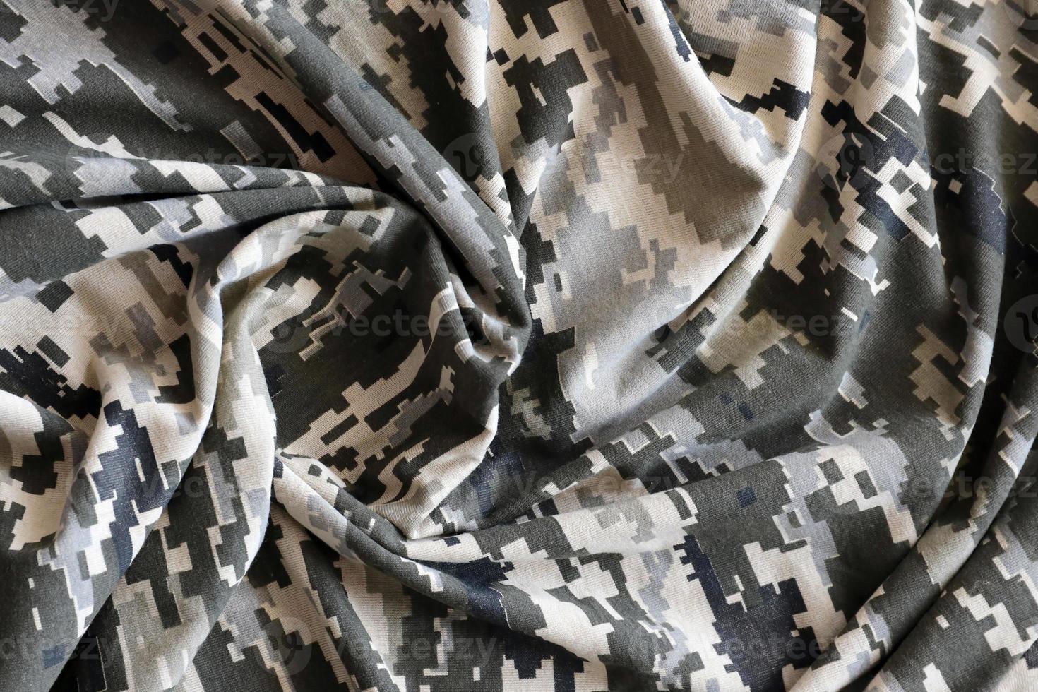 tyg med textur av ukrainska militär pixeled kamouflage. trasa med camo mönster i grå, brun och grön pixel former. officiell enhetlig av ukrainska soldater foto