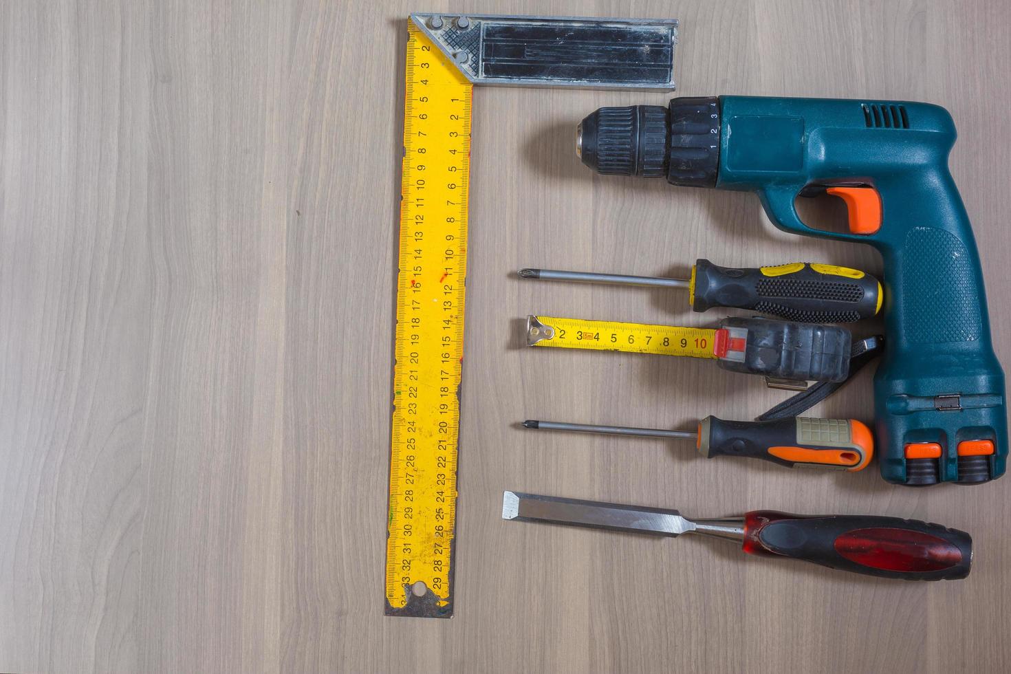annorlunda verktyg på en trä- bakgrund. hammare, borra, tång. skruvmejsel, linjal, skärande tång foto