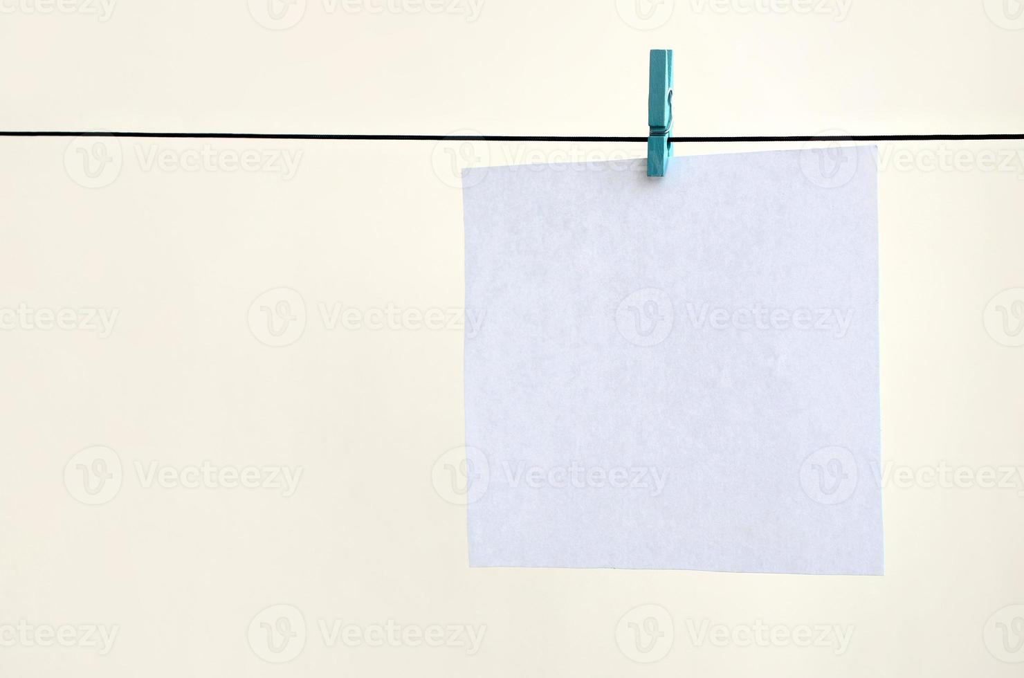 vit tom kort på rep, ljus vägg bakgrund. kreativ påminnelse, små ark av papper på gammal klädnypa, PM bakgrund foto