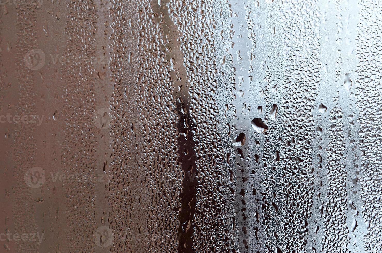 textur av en släppa av regn på en glas våt transparent bakgrund. tonad i grå Färg foto