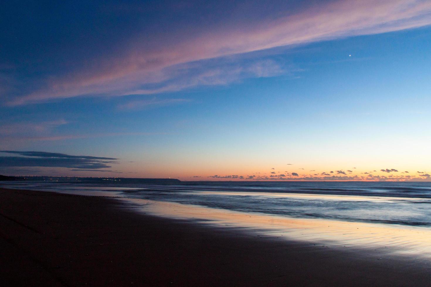 strand och vatten under solnedgången foto