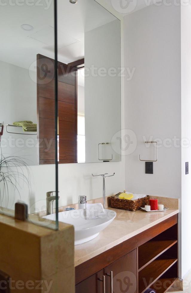 rymlig badrum i grå toner med uppvärmd golv, fristående badkar. foto