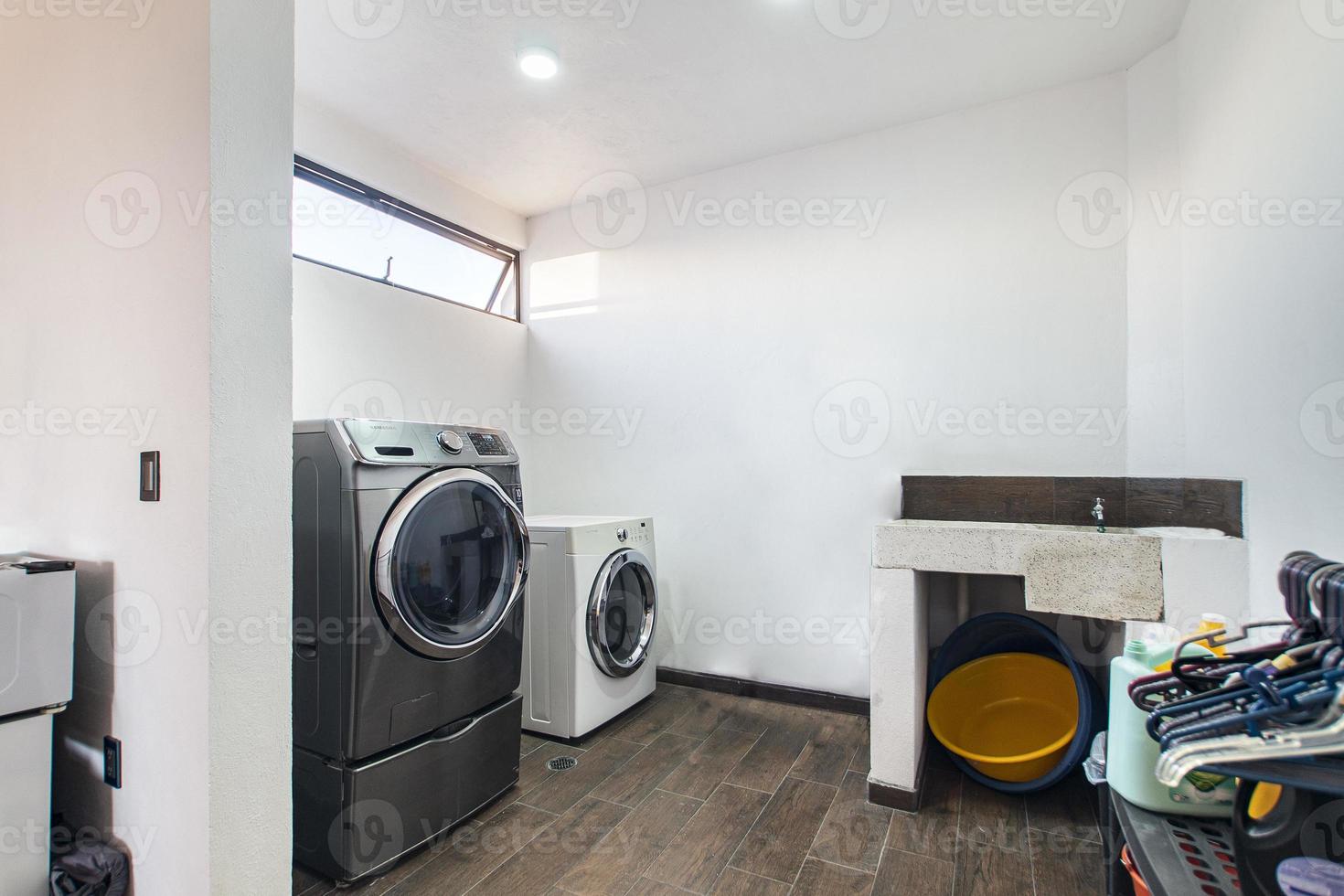 tvätt rum, med tvättning maskin, torktumlare, rengöringsmedel område, hand tvättning handfat, foto