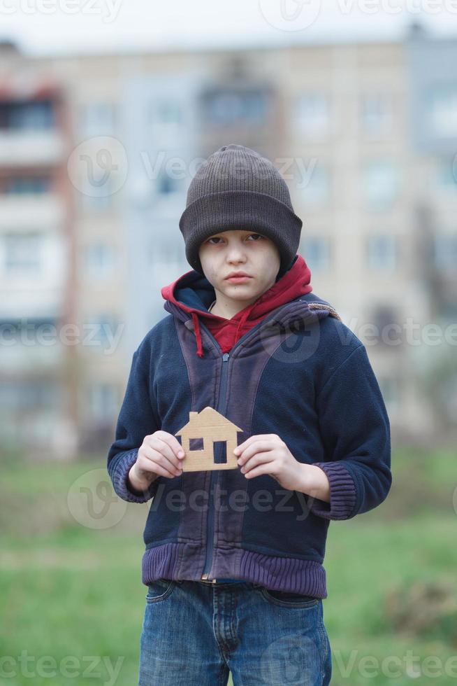 hemlös pojke som håller ett kartong foto