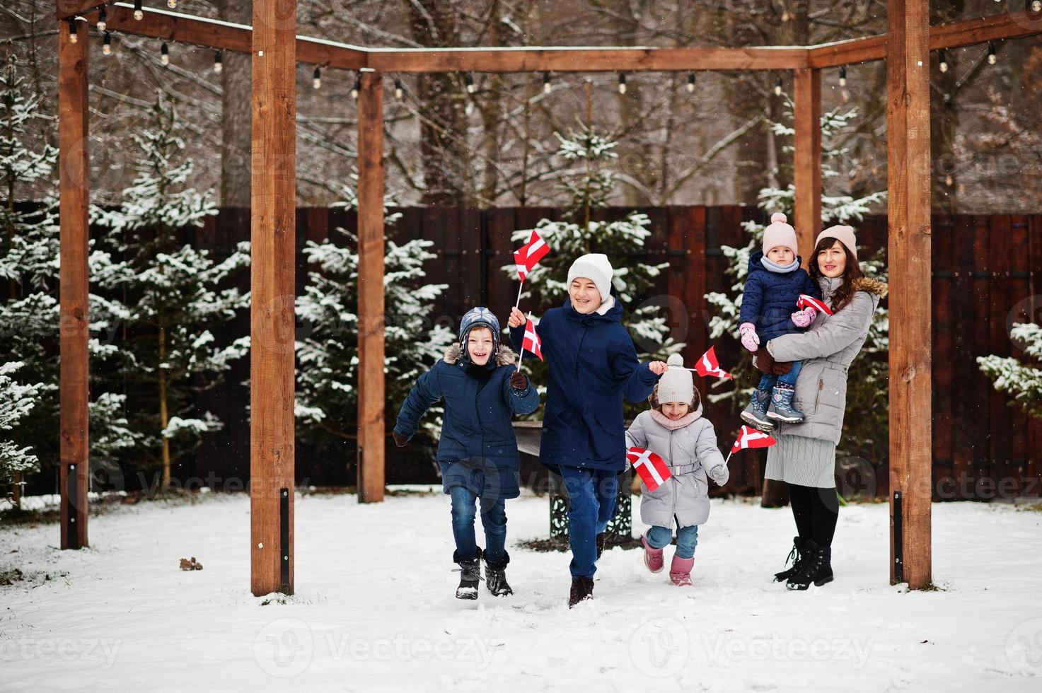 familj med danmarksflaggor utomhus på vintern. resa till skandinaviska länder. lyckligaste danskarnas . foto