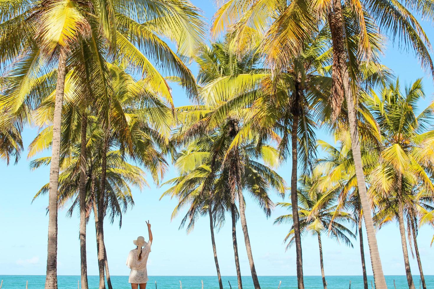 kvinna stående bland palmer på stranden foto