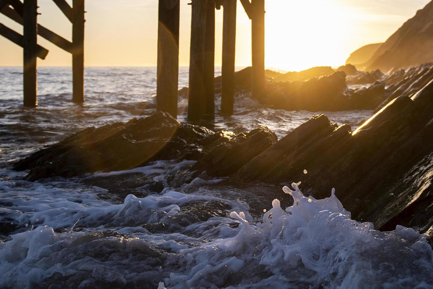 vågor på stranden under gyllene timmen foto