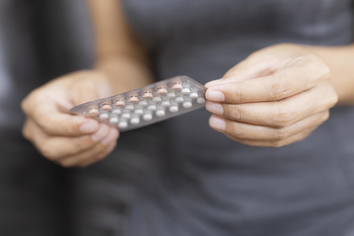 kvinna håller förpackning med preventivpillerar foto