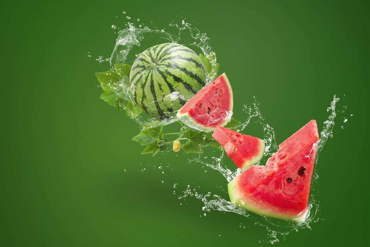 vatten stänk på vattenmelon på grön bakgrund foto