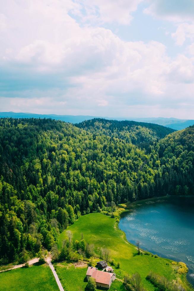 hus vid sjön och skogen med molnig blå himmel foto