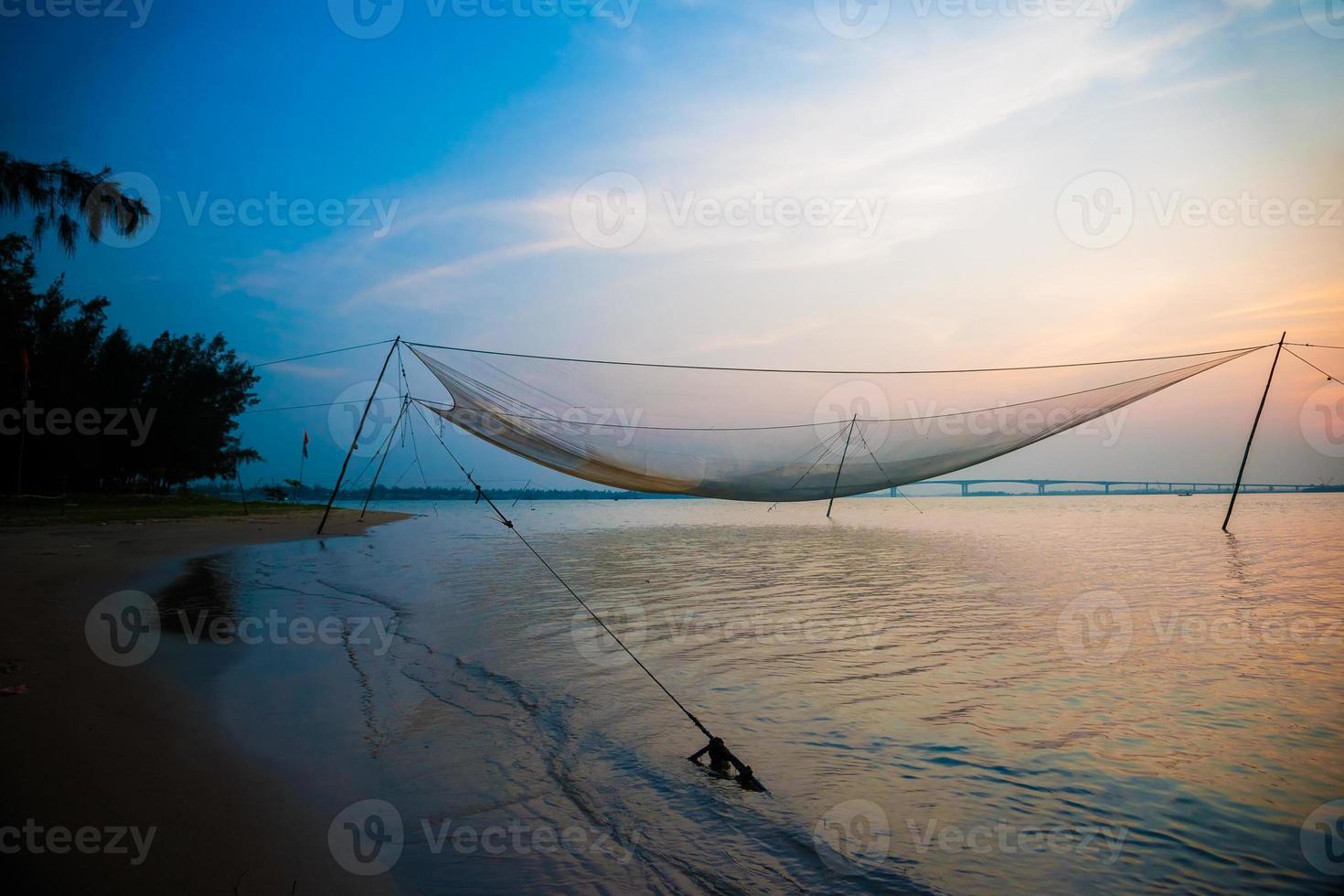 lugn scen med fisknät mot lila solnedgång. foto
