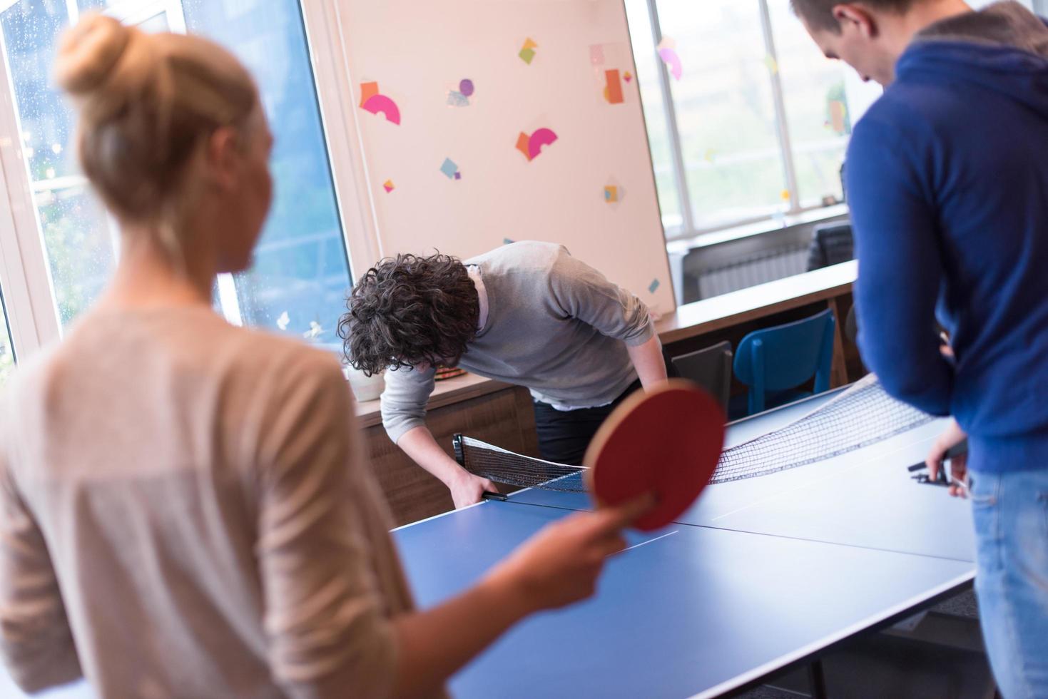 börja företag team spelar ping pong tennis foto