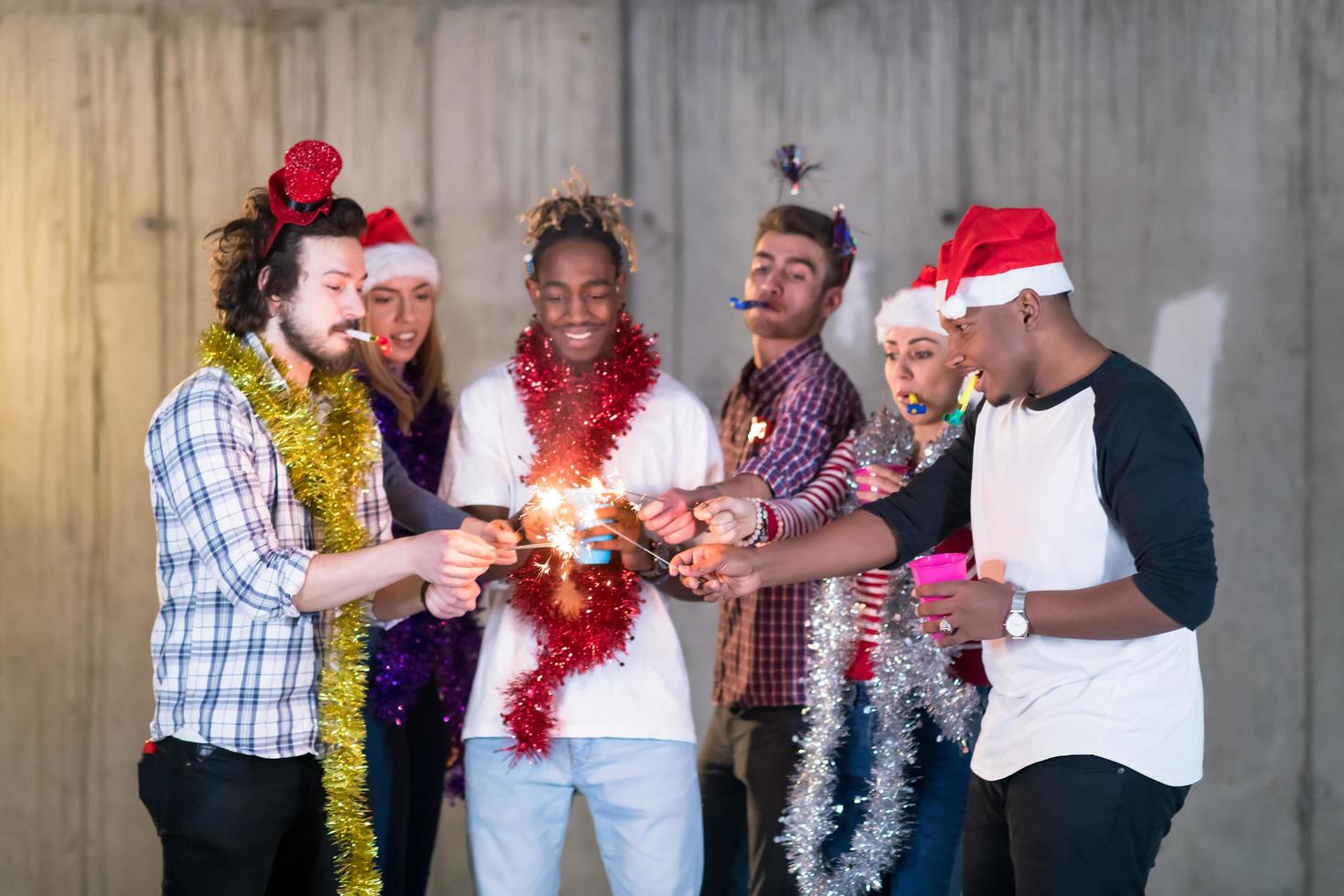 multietnisk grupp av tillfällig företag människor belysning en sparkler foto