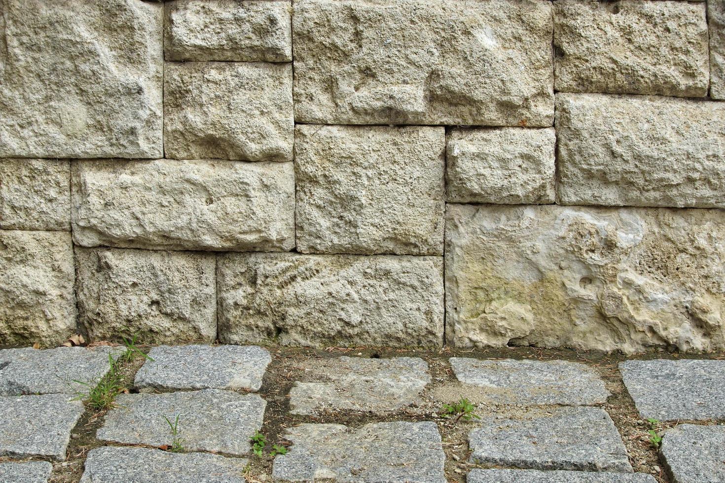grå sten kakel vägg och kullersten fragment foto