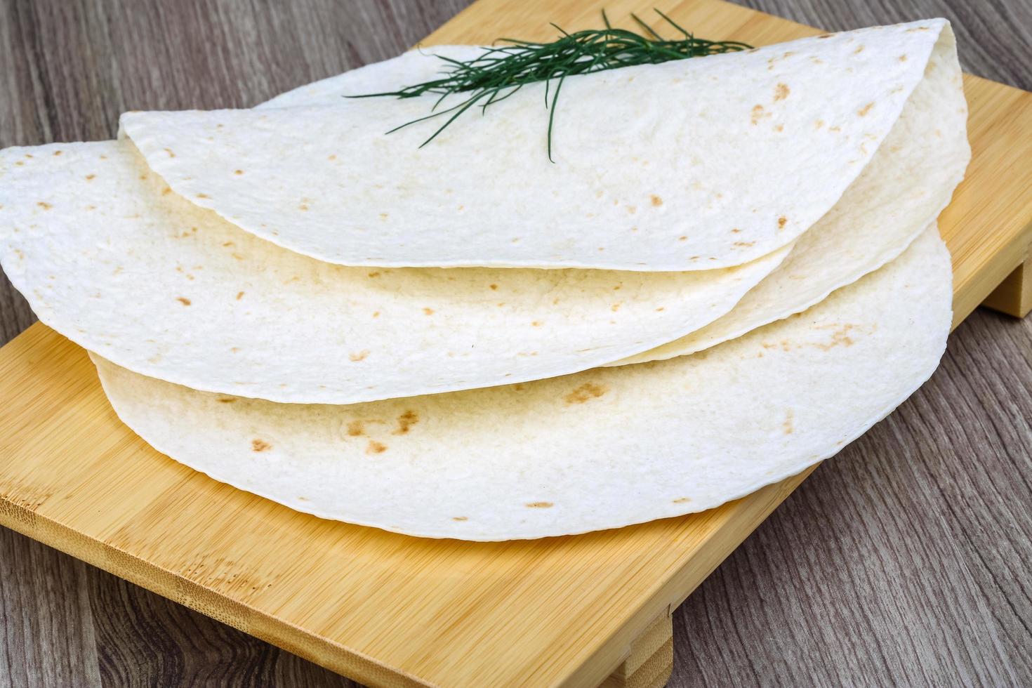 tortillas på trä- styrelse och trä- bakgrund foto