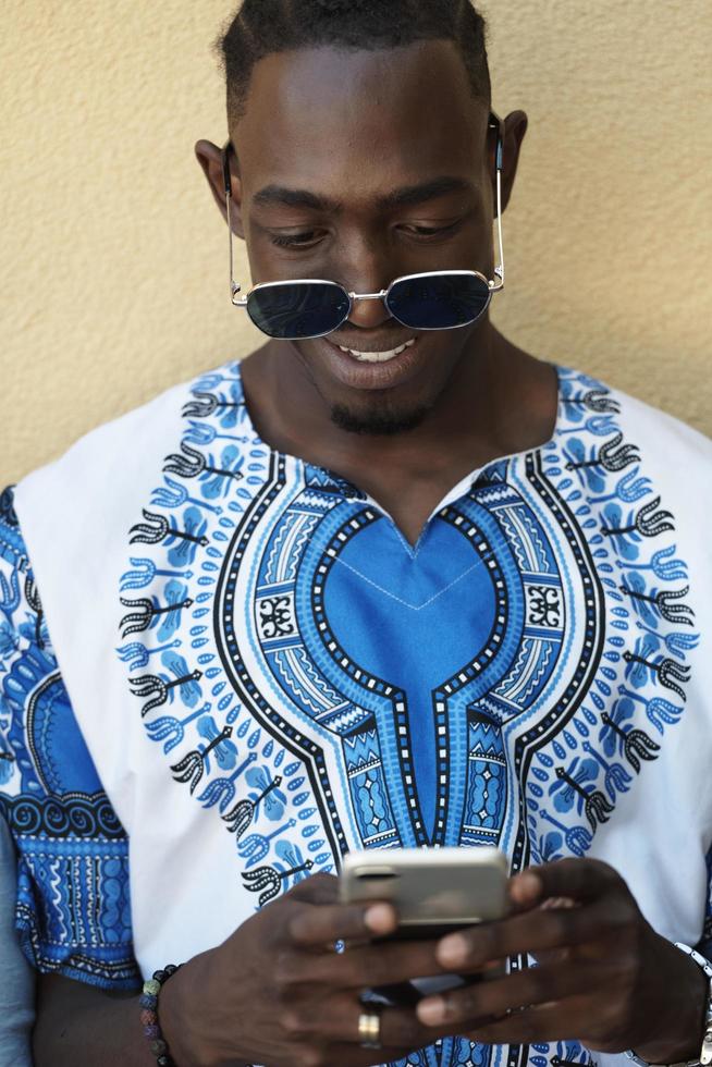 inföding afrikansk svart man använder sig av smart telefon foto