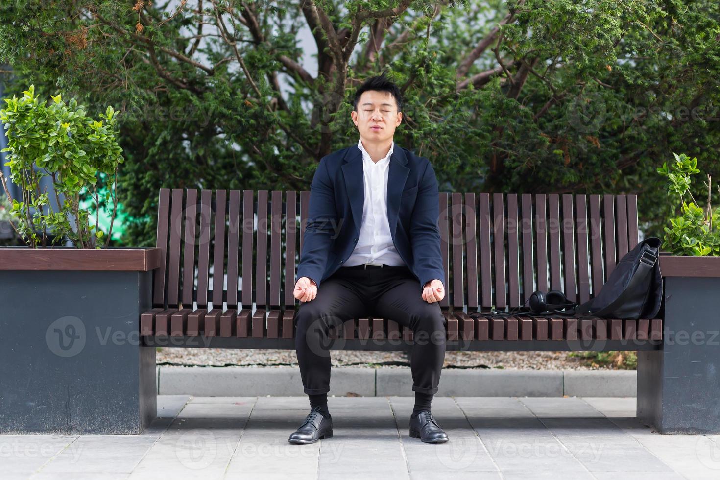 asiatisk affärsman utför andas övningar påfrestande till lugna påfrestning foto