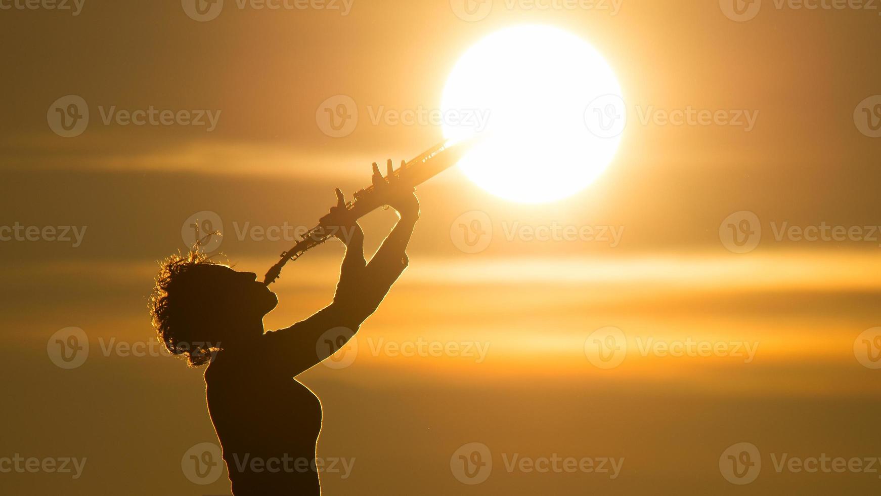kvinna spelar en saxofon på de Sol foto
