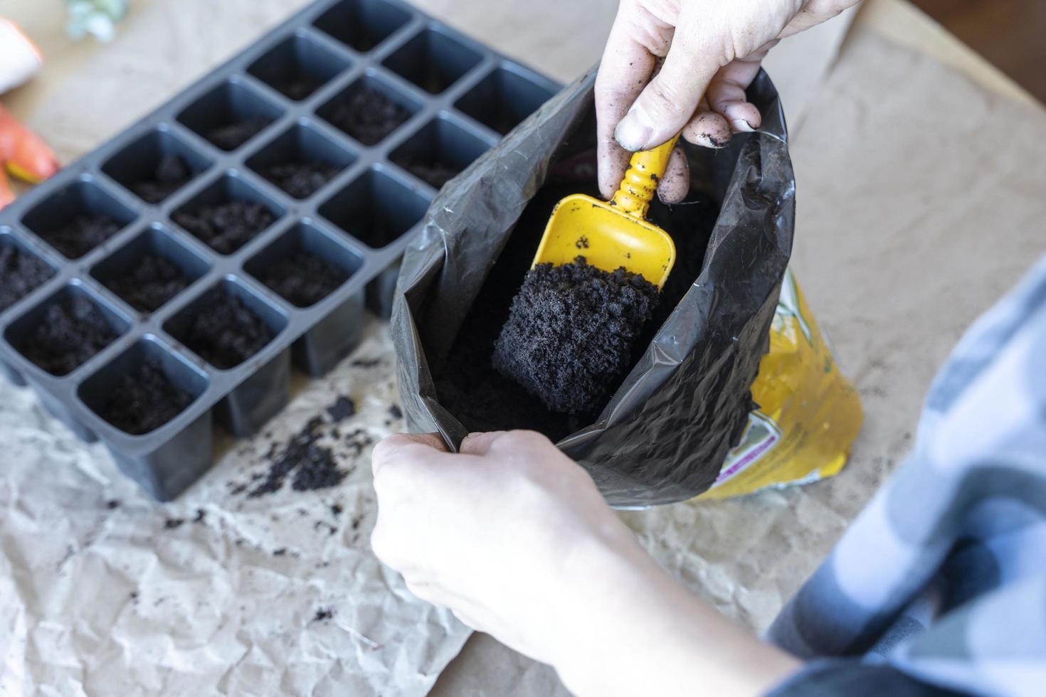 de bearbeta av fyllning kastruller för plantor med jord foto