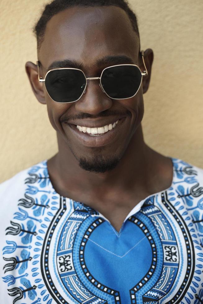 porträtt av en leende ung afrikansk man bär traditionella kläder foto
