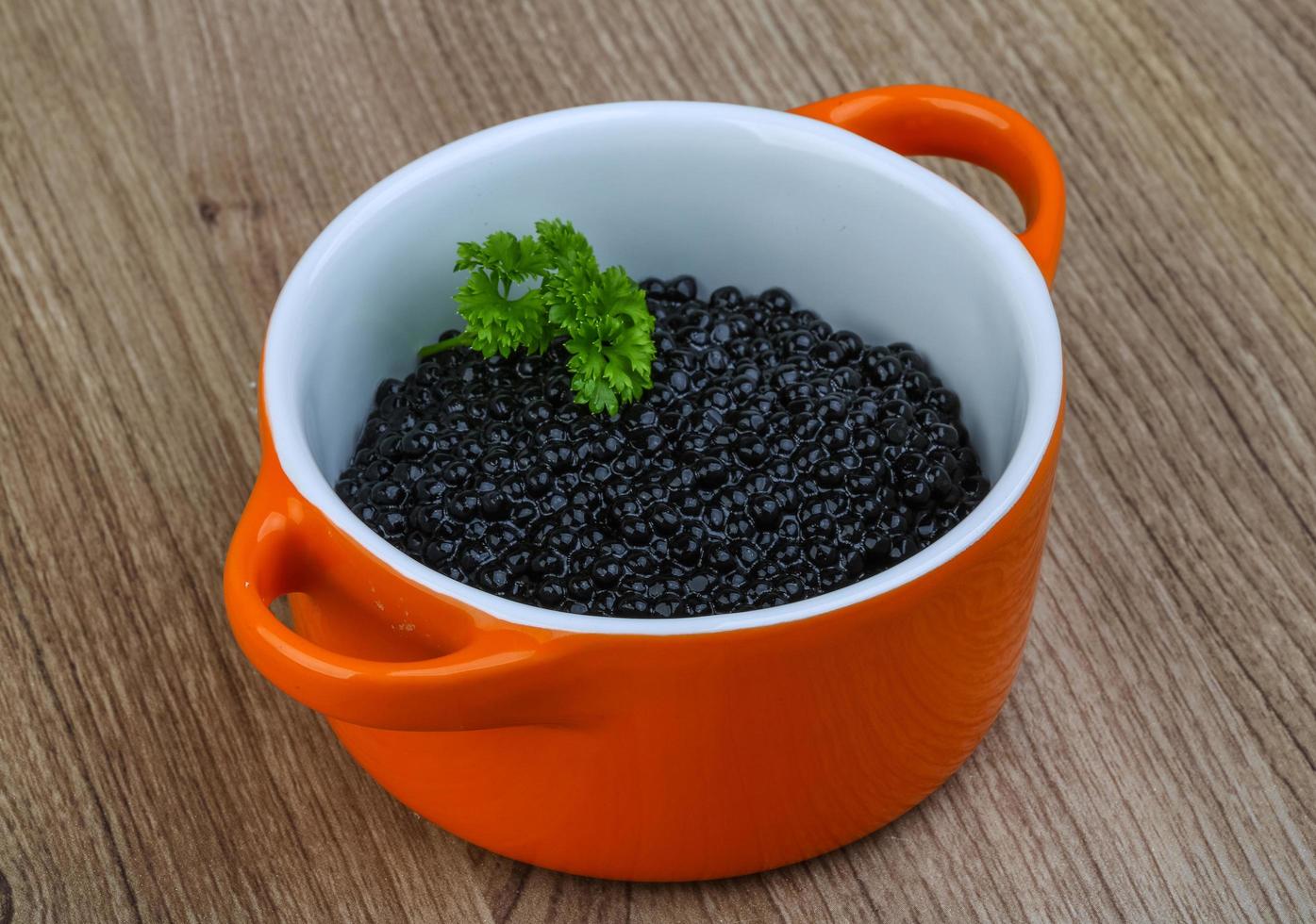 svart kaviar i en skål på trä bakgrund foto