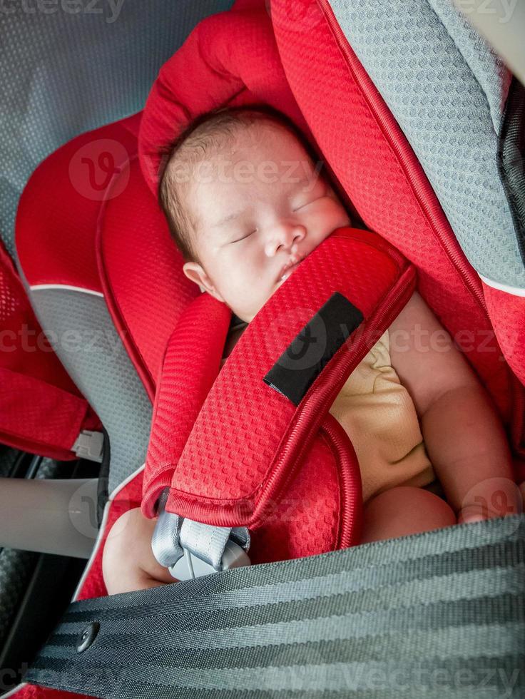 nyfödd bebis flicka sömn i bil sittplats foto