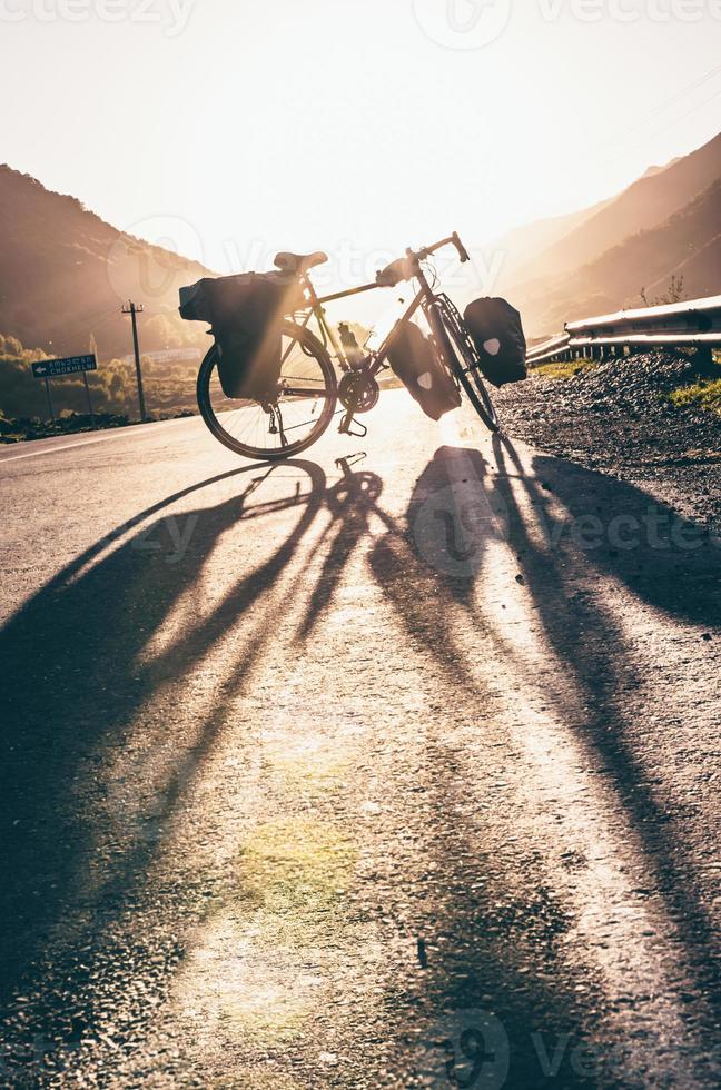 bakgrund bild av stående touring cykel utan cyklist på de väg med nocars. cykling i en landsbygden. kazkbegi nationell parkera. georgia.2020 foto