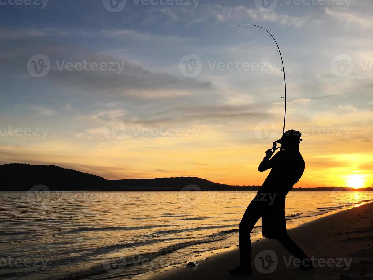 ung man fiske på solnedgång foto