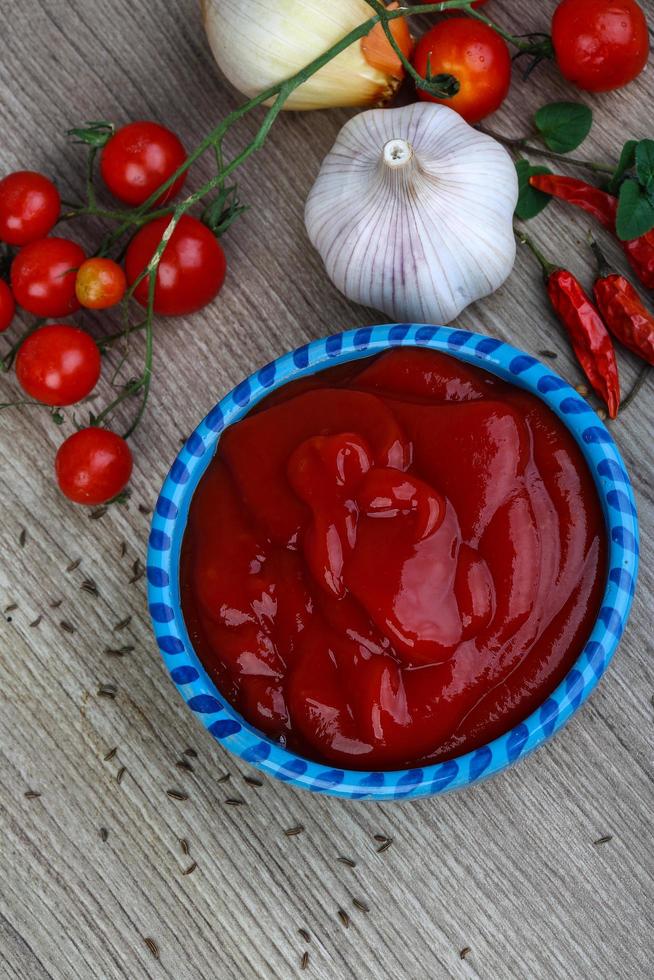 tomat ketchup i en skål på trä- bakgrund foto