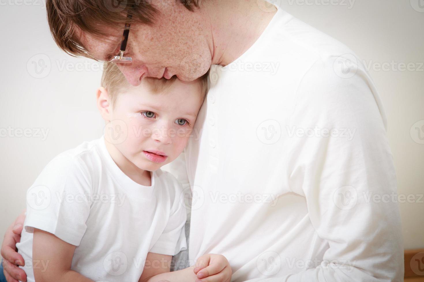 far tröstande son i tårar foto