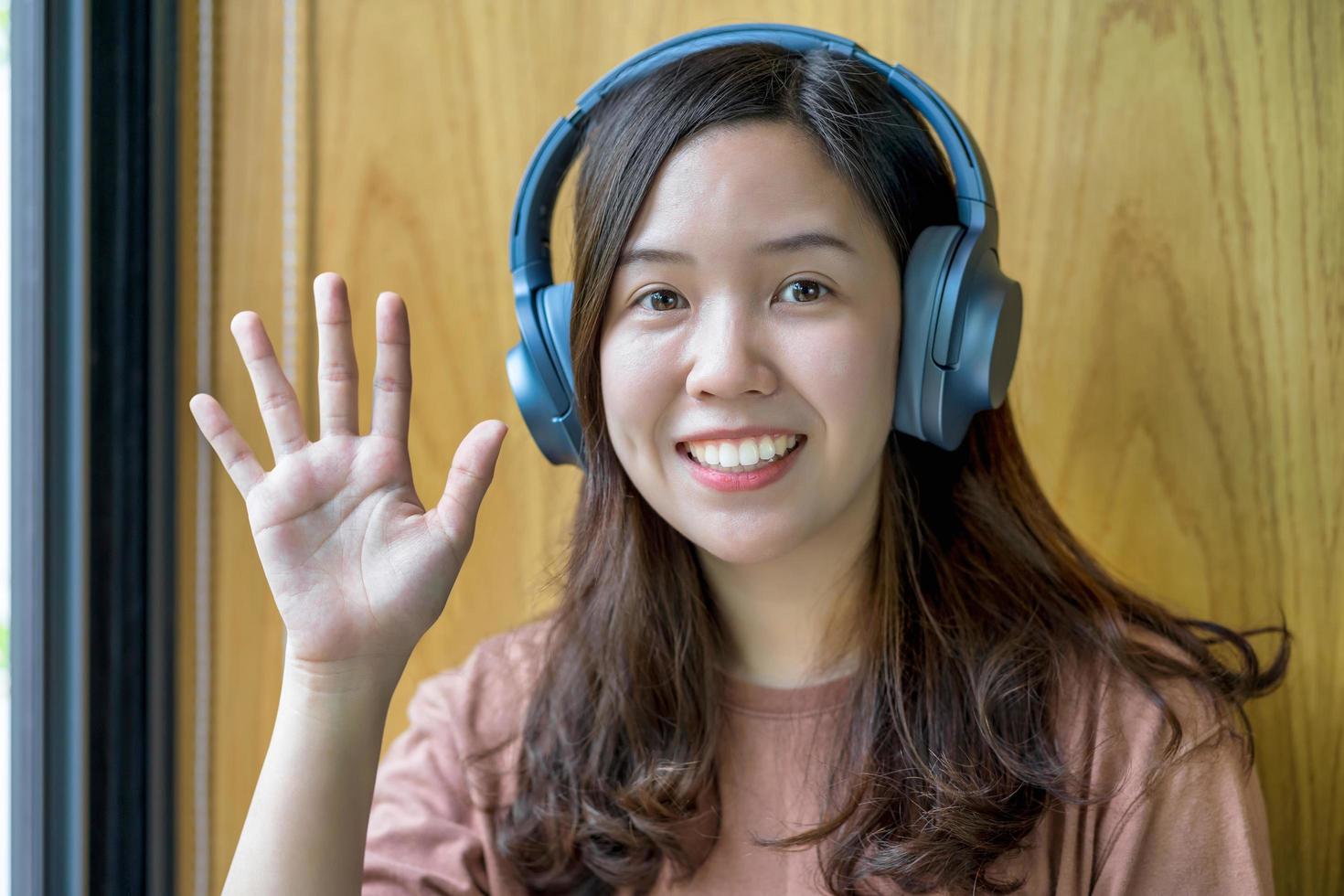 asiatisk ung kvinna viftande hand foto