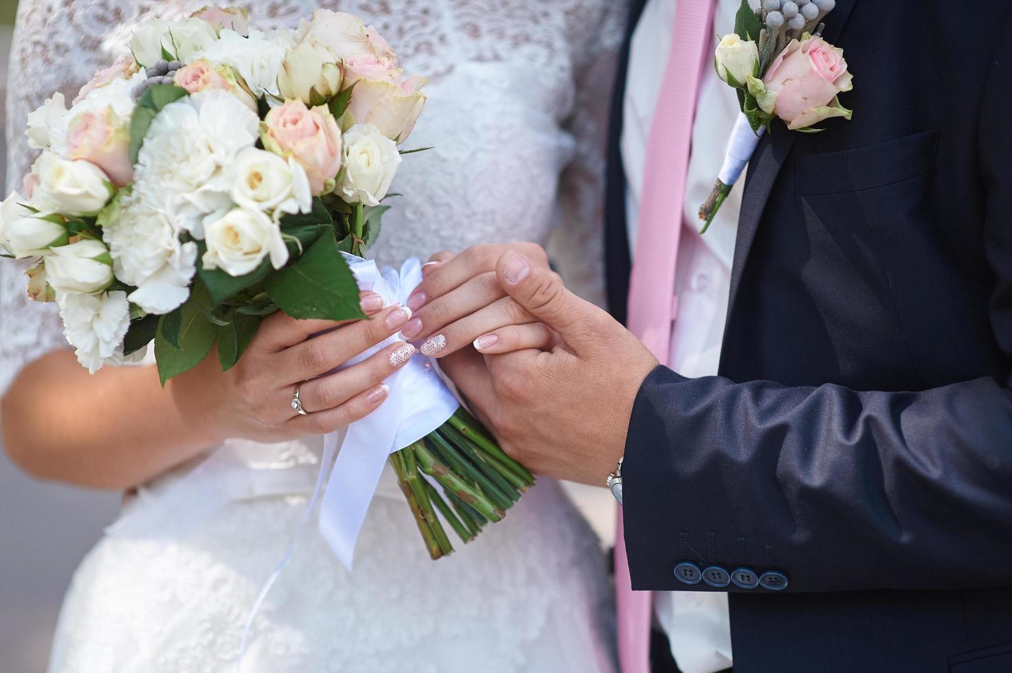 brudgummen håller sin bruds hand foto