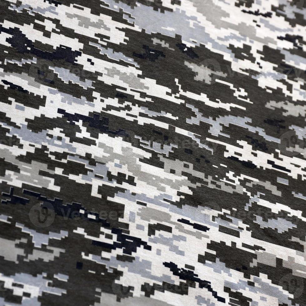 tyg med textur av ukrainska militär pixeled kamouflage. trasa med camo mönster i grå, brun och grön pixel former. officiell enhetlig av ukrainska soldater foto