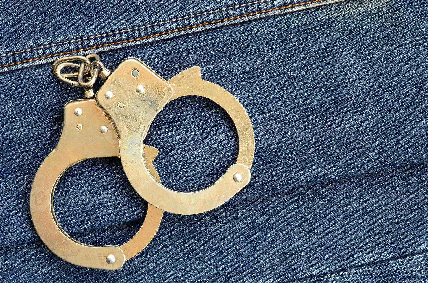 polis stål handklovar liggande på mörk blå jeans bakgrund foto