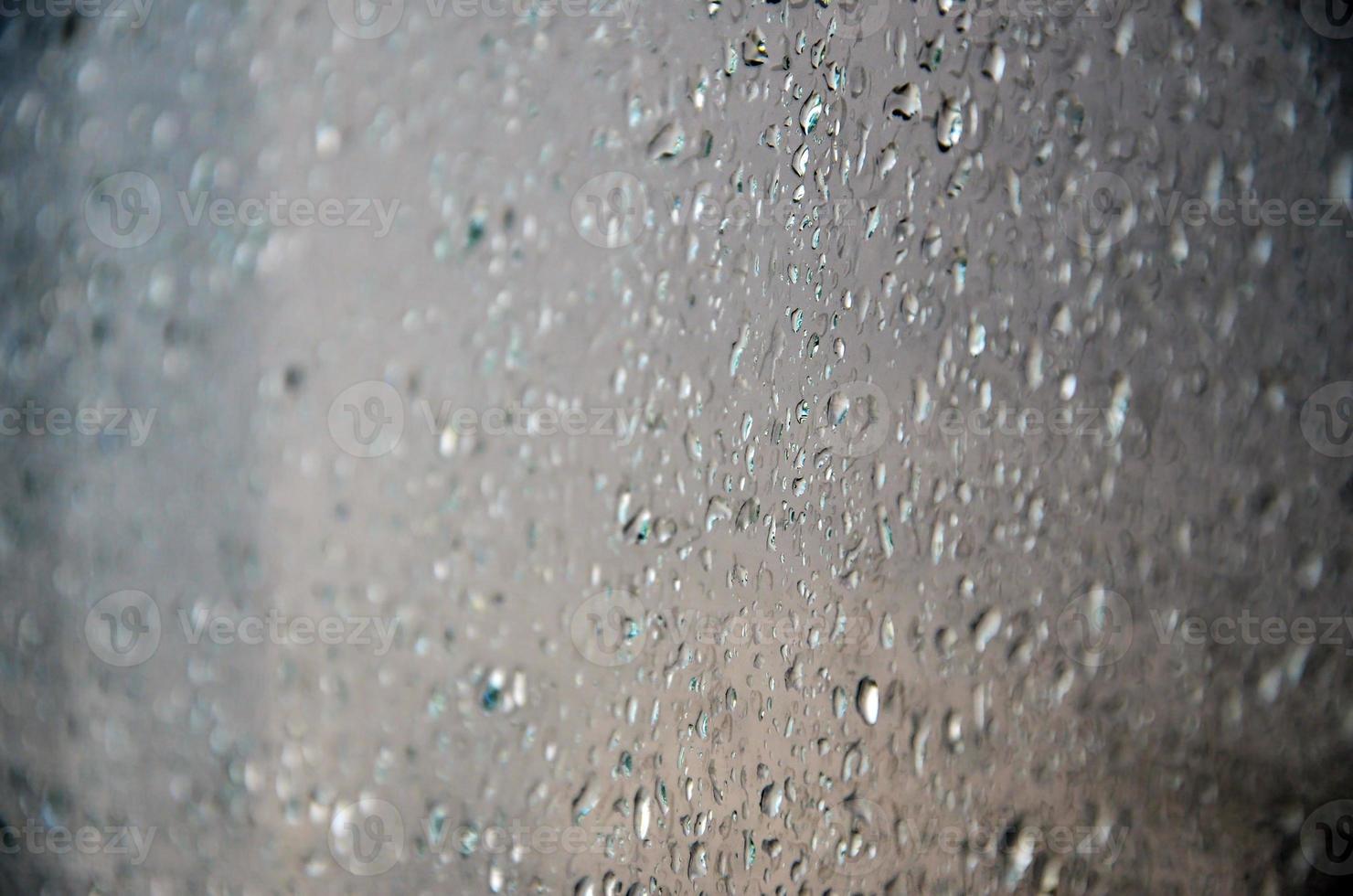 bakgrund bild av regn droppar på en glas fönster. makro Foto med grund djup av fält