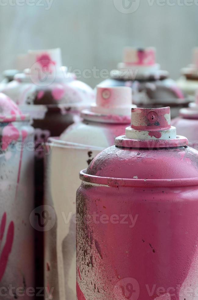 en massa av smutsig och Begagnade aerosol burkar av ljus rosa måla. makro fotografera med grund djup av fält. selektiv fokus på de spray munstycke foto